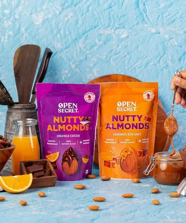 A product-focused shot for Open Secret's Nutty Almonds, showcasing two flavor varieties in one frame. This composition is great for website banners or ads comparing different product offerings.