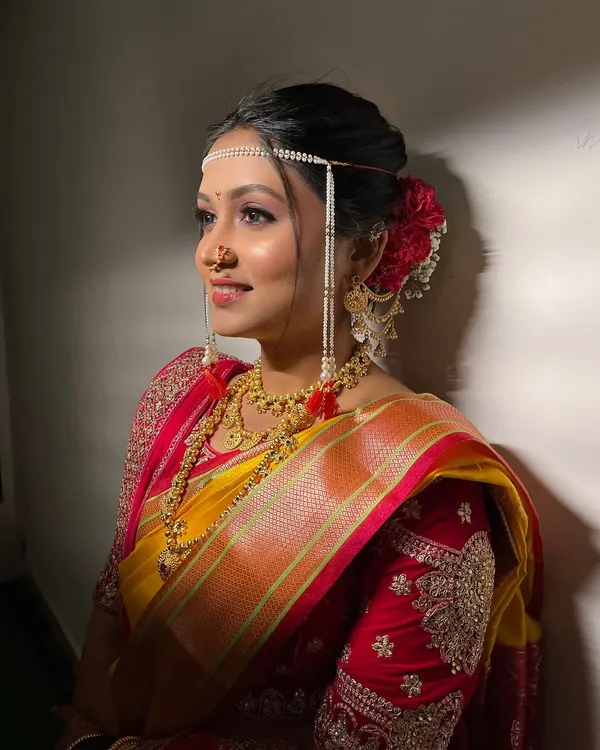 A side profile of my minimalist bride, showing the elegant Khopa hairstyle with a red rose and the delicate mundavalya.