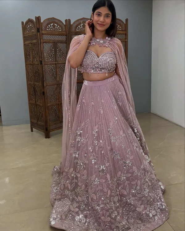 A stunning mauve Indo-western lehenga with a dramatic attached cape. This pre-loved designer piece is perfect for making a fashion-forward statement.