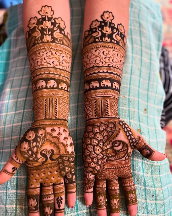 This design showcases a variety of classic motifs on both hands. You can see peacocks, swans, elephants, and lotuses combined with leafy vines and geometric bands.