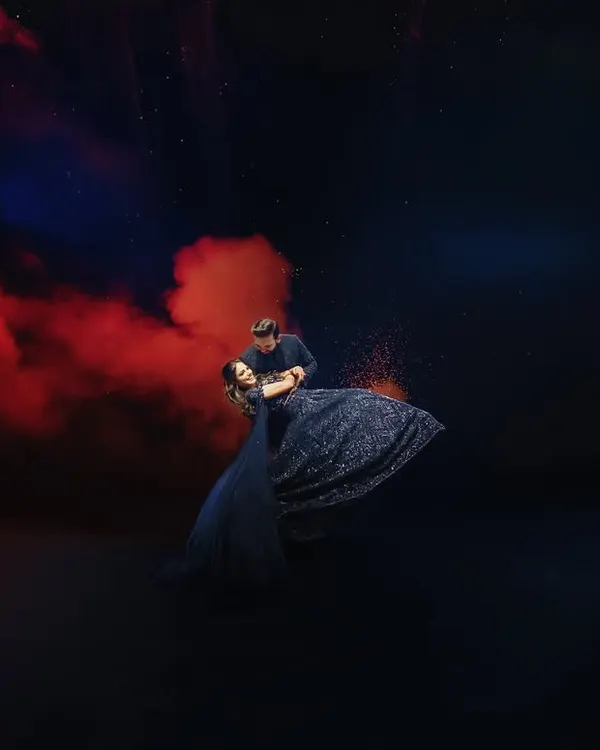 A dance under a sky of red smoke and fireworks. This is a perfect example of a highly stylized and dramatic pre-wedding shot, creating a powerful and artistic visual that is full of passion.