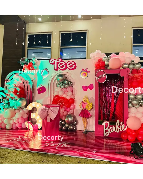 "Come on Barbie, let's go party!" This glamorous Barbie-themed stage is a dream in shades of pink, featuring a life-sized Barbie box photo booth, neon signs, and a light-up number three.