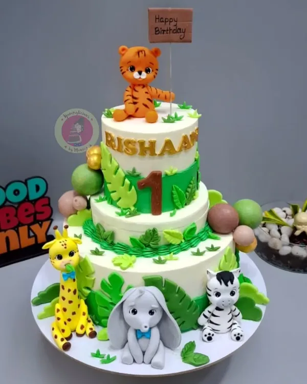 A special jungle-themed cake for little Rishaan's first birthday, complete with a rotating top tier and adorable fondant animals.