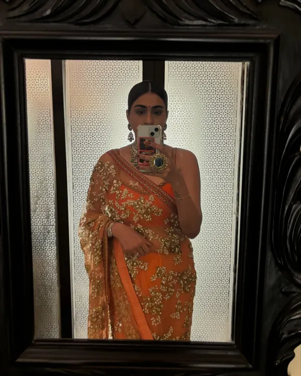 A mirror selfie in a stunning orange Sabyasachi saree. This is my go-to for palace weddings, combining traditional elegance with a vibrant color.