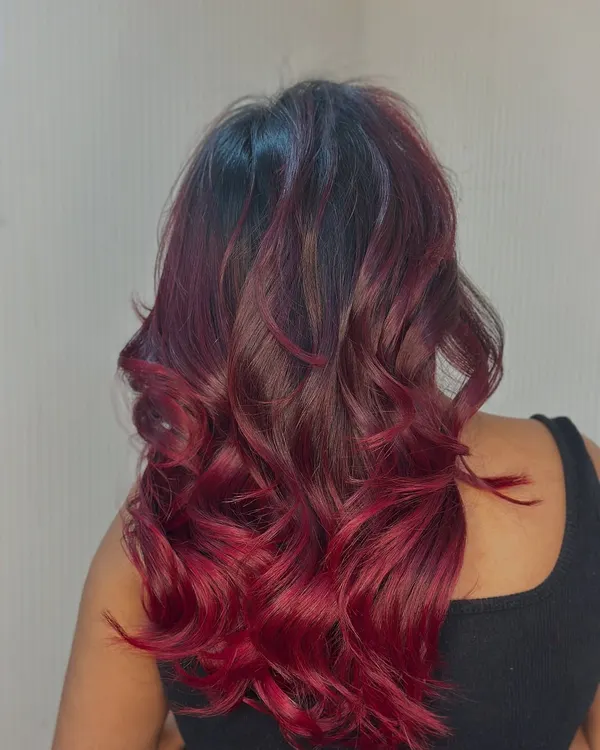 Fire in her hair. This stunning bright red ombre is styled with bouncy curls to show off the intense, vibrant color.
