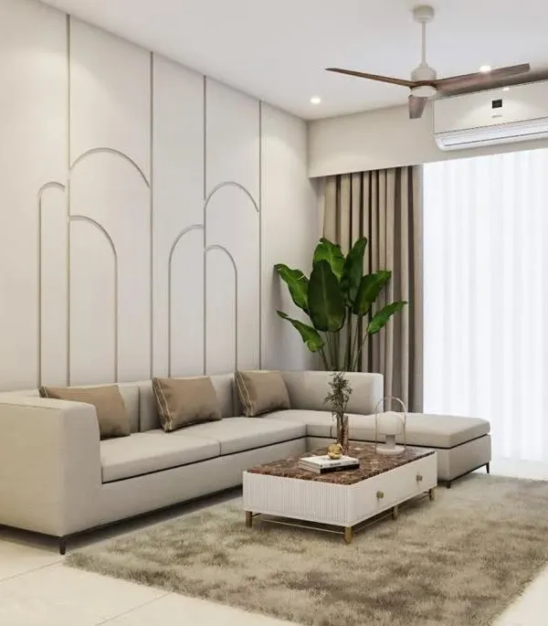 A comfortable and stylish living room with a large L-shaped sofa. The back wall features elegant arched paneling, creating a subtle yet sophisticated backdrop for the entire space.