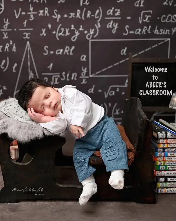 A tiny professor, fast asleep on the job. This creative and adorable one-month-old photoshoot captures the quiet, sleepy nature of the newborn phase in a fun and unique way.
