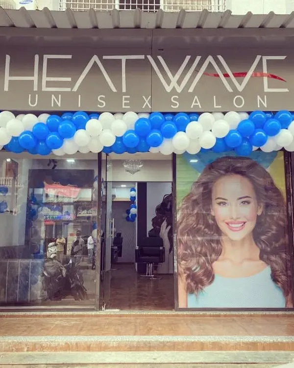 A blue and white spiral balloon arch for the inauguration of Heatwave Unisex Salon, creating a clean and professional look.