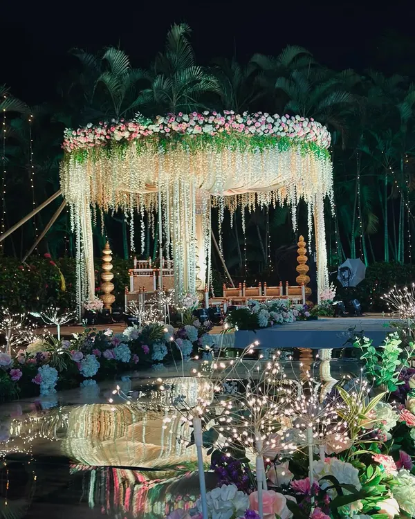 This is what we live for: creating a blissful, dream-like space for your most important moments. This poolside floral mandap, lit up against the night sky, shows how we blend nature and elegance to create pure magic.