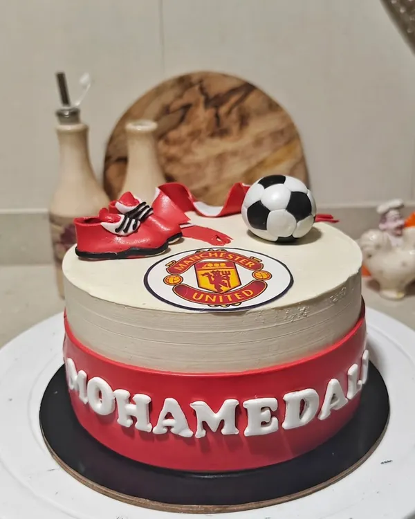 A cake for a true Manchester United fan. I included the iconic logo, a fondant scarf, and football boots to bring the theme to life. It’s a great custom birthday cake for any sports lover.