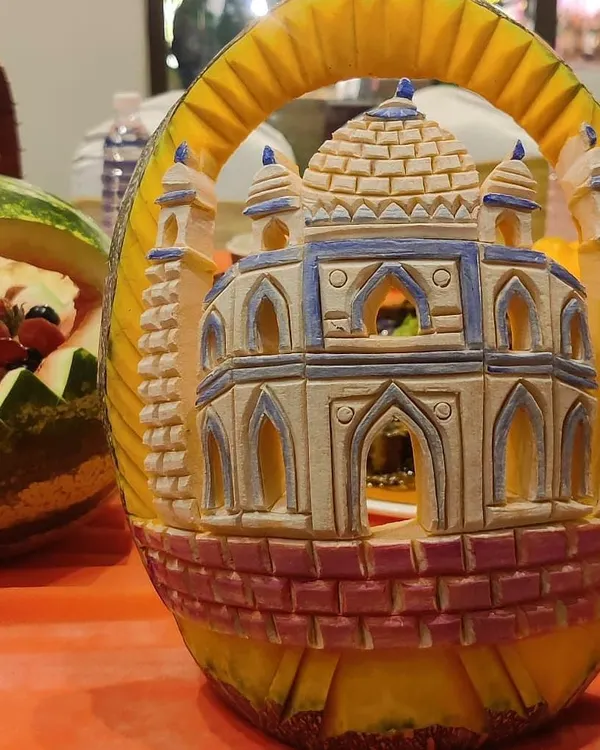 A testament to our presentation skills. This is an intricate carving of a monument, likely the Taj Mahal, made from a pumpkin. It’s a stunning centerpiece that showcases our attention to detail.