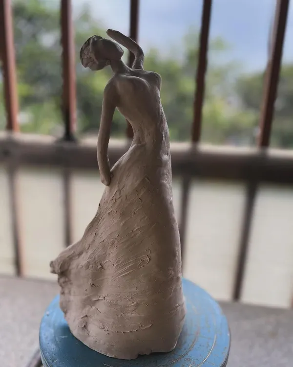 A clay sculpture of a dancing woman, captured before firing. I wanted to express a sense of graceful movement in her pose.