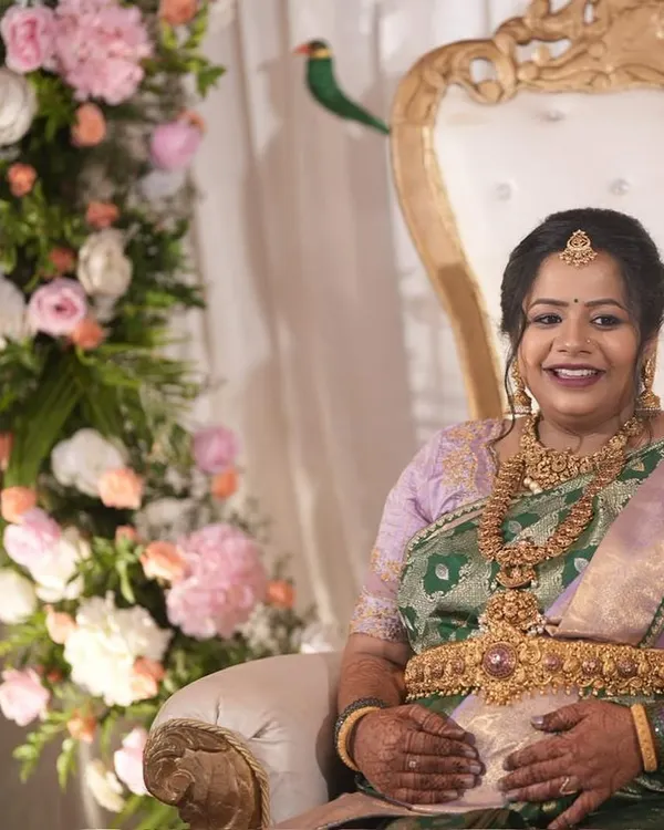 Our client Pavithra Gowda, radiant at her baby shower. The lavender and green dual-tone silk saree drapes her in serenity and renewal, mirroring the beautiful journey of motherhood.