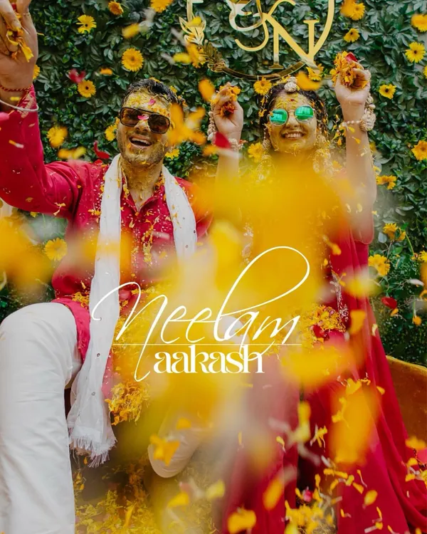 A fun and vibrant shot of the couple during their Haldi, showered with marigold petals.