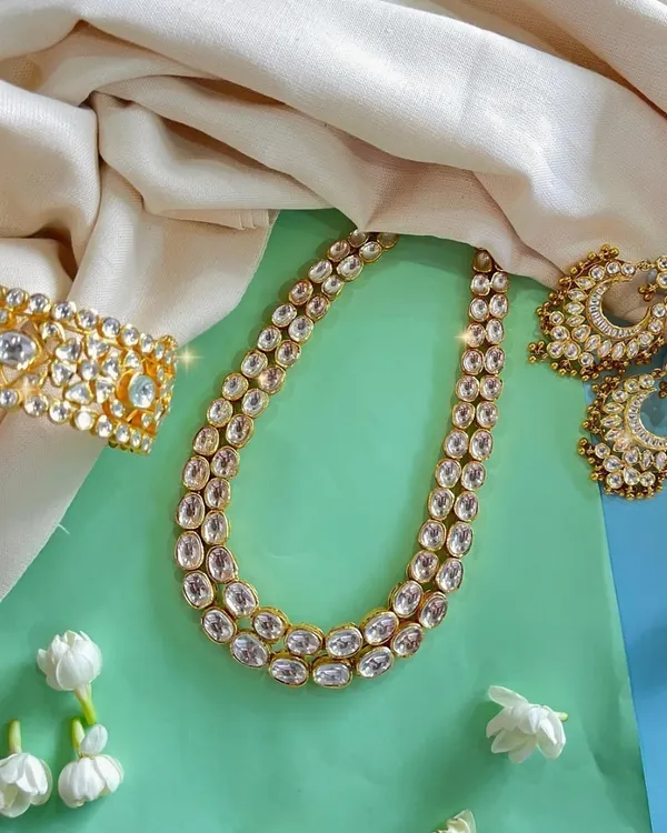 Add a touch of royalty to your collection with our stunning Kundan jewellery set. The necklace, earrings, and wide cuff bracelet are perfect for any grand occasion.