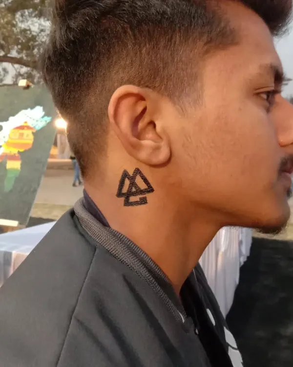 A bold geometric symbol, the Valknut, painted on the neck. This type of sharp, symbolic art is very popular and makes a strong statement.