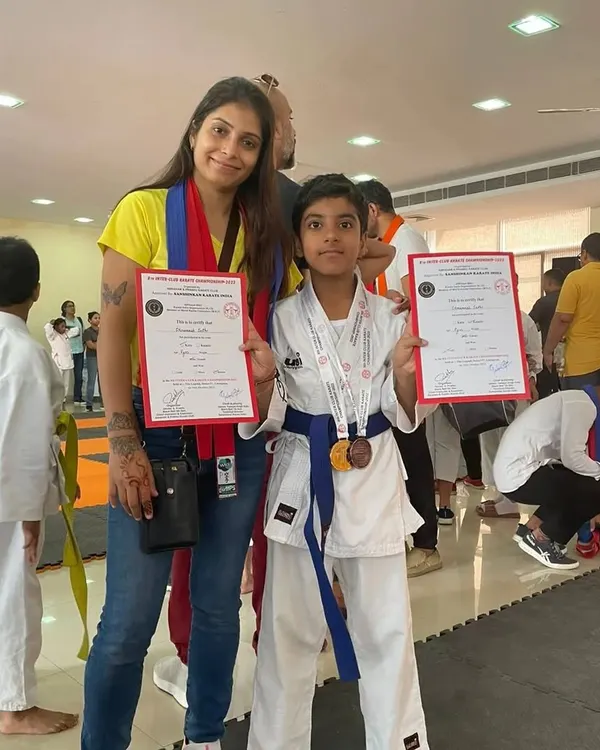 Posing with one of my students who proudly displays his certificates and medal after a championship. Seeing their hard work pay off is one of the most rewarding parts of being a coach.