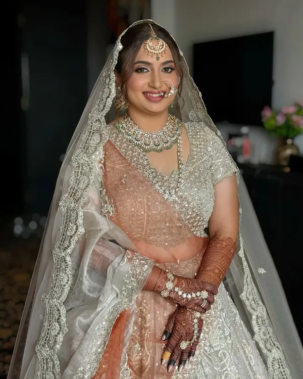 The final look for my beautiful bride Dhruvi. Her makeup features a soft, dewy base and neutral tones to complement her stunning silver and peach lehenga, ensuring she looked effortlessly radiant.