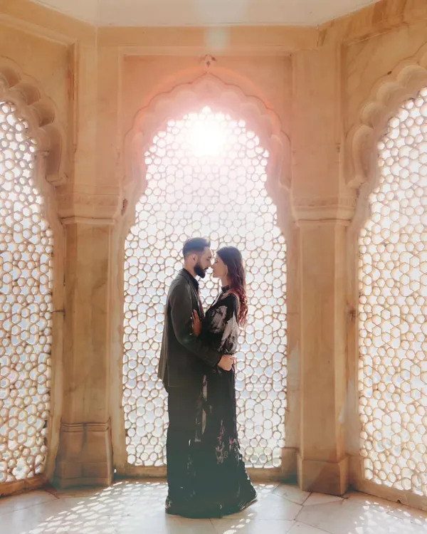 A classic pre-wedding portrait set against a beautifully sunlit palace window. This is the essence of our royal shoots, combining architectural beauty with romantic poses to create timeless images.