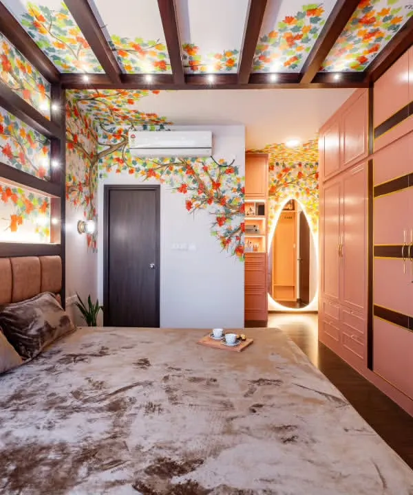 This master bedroom from Project Sakura is an immersive, artistic retreat. A hand-painted autumn mural flows across the walls and ceiling, complemented by blush-toned wardrobes and a statement arched mirror.