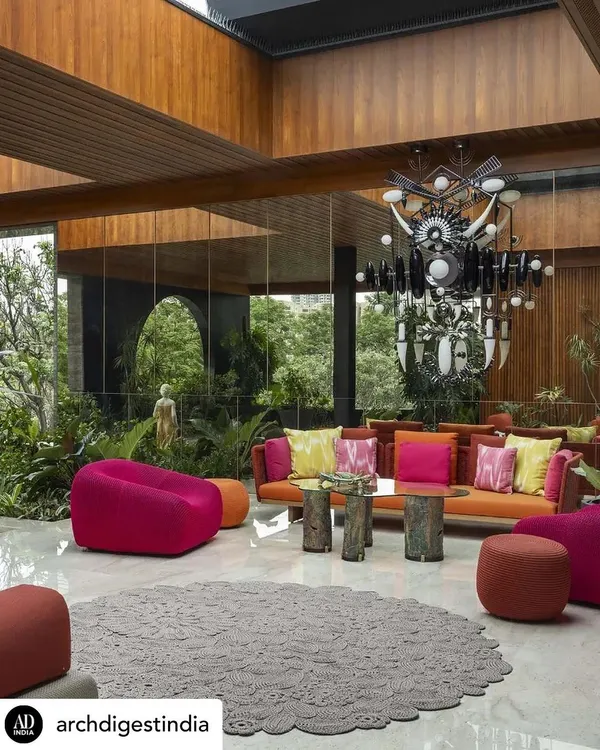 This is what I mean by an urban oasis. We designed this entertainment lounge with a retractable ceiling and vast glass walls that completely open up, blurring the line between the indoors and the lush garden outside. The vibrant colors and comfortable seating make it the perfect space for large gatherings, all while being surrounded by nature.