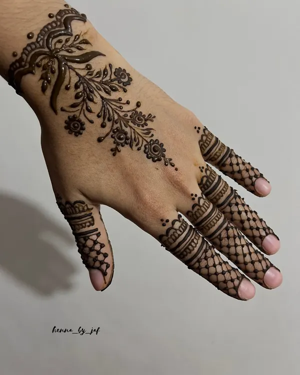 A beautiful Arabic floral vine design that wraps around the wrist like a corsage and trails down the back of the hand. The fingers are detailed with delicate net patterns.