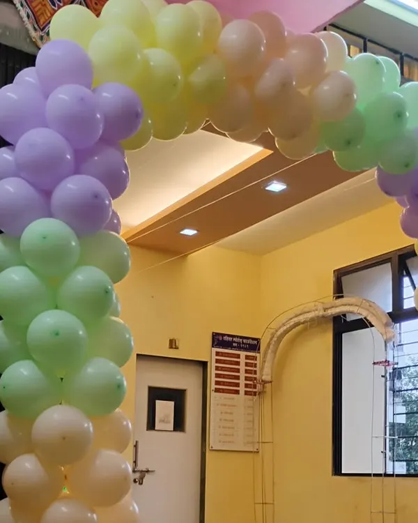 A soft and welcoming entrance for any daytime event. This balloon arch uses a beautiful pastel rainbow palette of purple, green, yellow, and peach, creating a cheerful and inviting entryway.