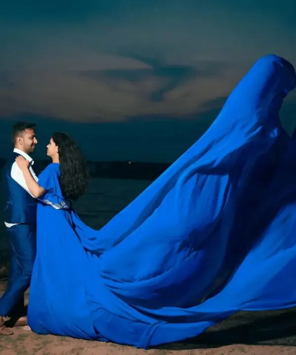 Our royal blue flying dress creates an unforgettable image against the twilight sky. The massive trail appears to take flight, perfect for a dramatic couple's portrait by the water.