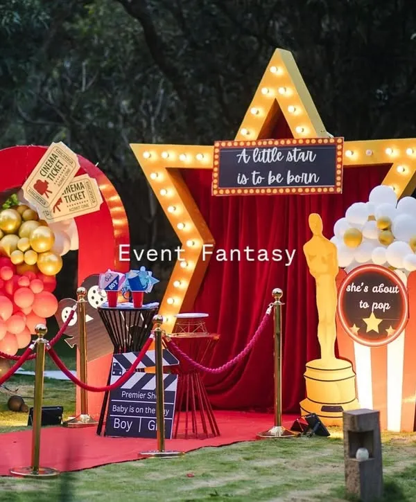 The full 'Lights! Camera! Baby!' setup, ready for the premiere. This movie-themed baby shower features a red carpet, a light-up star, and fun props like a giant popcorn box and film reel, creating an unforgettable experience.