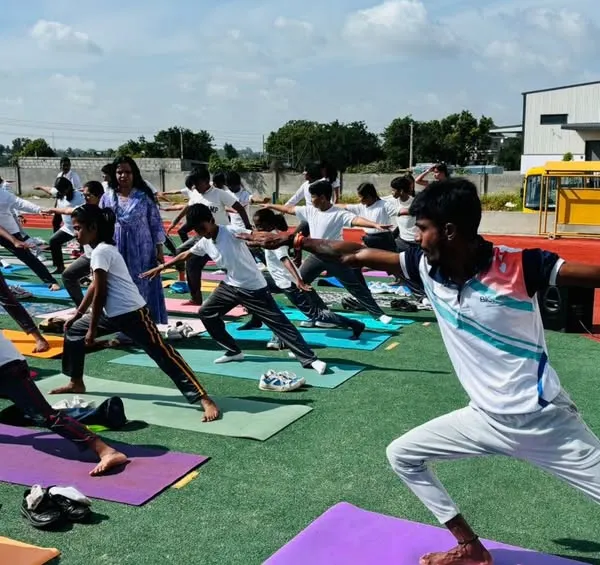 Our students practice the warrior pose during an outdoor yoga session. We integrate yoga into our curriculum to enhance flexibility, focus, and inner peace.