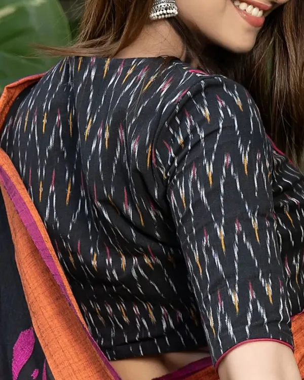 Black ikat ka classy touch, pink piping ka bold andaaz. This V-neck, front-open blouse is ready for your wardrobe, blending traditional handloom with a modern silhouette.