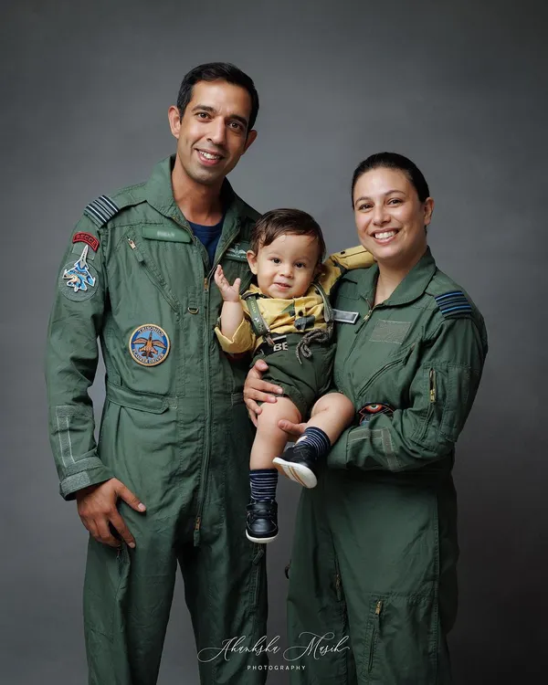 A proud family portrait of Airforce pilots with their little one. This image captures their unity, love, and the unique story they share.