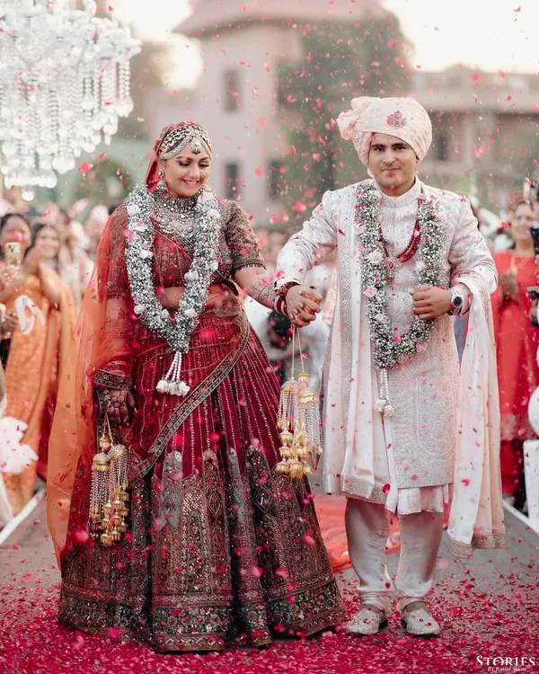 A classic wedding portrait of Rhea and Abhimanyu, walking down the aisle, showered in petals, the epitome of a happy couple.