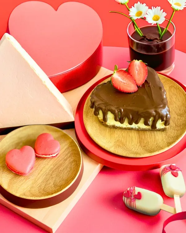Our Valentine's Day assortment is made for sharing. This beautiful spread includes a heart-shaped cheesecake, heart macarons, and cakesicles, all in a romantic pink and red theme.