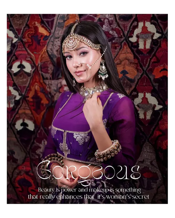 A gorgeous portrait from a bridal look photoshoot. The model's regal purple outfit and intricate jewelry are captured against a rich, patterned backdrop, creating a royal and elegant image.