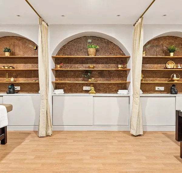 At the Vedic Spa, the treatment areas are designed for ultimate tranquility. I used arched alcoves with warm, textured backdrops and soft, indirect lighting to create individual havens. The simple curtains provide privacy while maintaining a light, airy feel.
