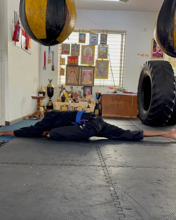 A full pancake stretch, a deep stretch for the hips and hamstrings. This level of flexibility is crucial for high kicks and injury prevention.