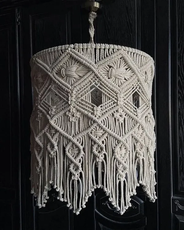 This intricate macrame hanging lamp is a true statement piece. The detailed knot work creates beautiful light patterns, adding a warm and cozy ambiance to any room.