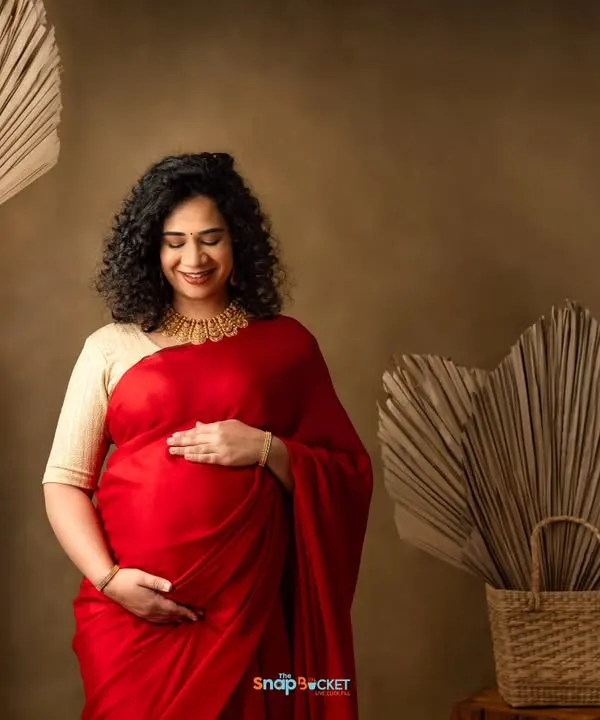 The elegance of a saree for a maternity shoot is just unmatched. This mom-to-be looks absolutely radiant in a vibrant red saree, cradling her bump in my boho-themed studio.