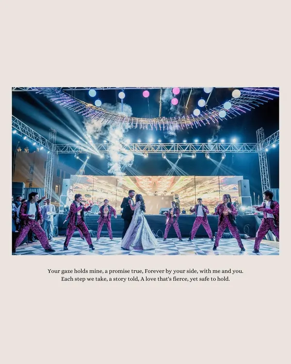 A grand performance on the Sangeet stage. The couple is surrounded by dancers, smoke, and lights, creating a spectacular moment that feels like a scene from a movie.