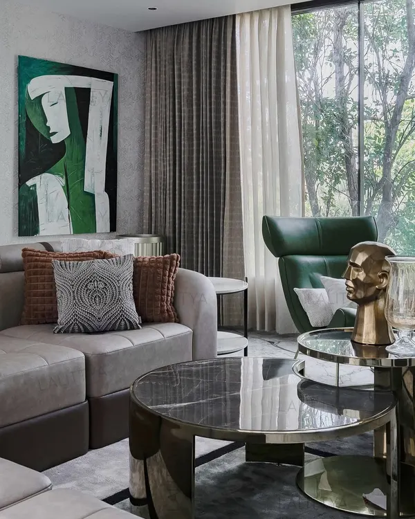 This family lounge in our Chennai project was designed as a retreat. A large window frames the view of the trees outside, blurring the boundary between inside and out. The sculptural green leather chair provides a perfect spot for stillness and reading.