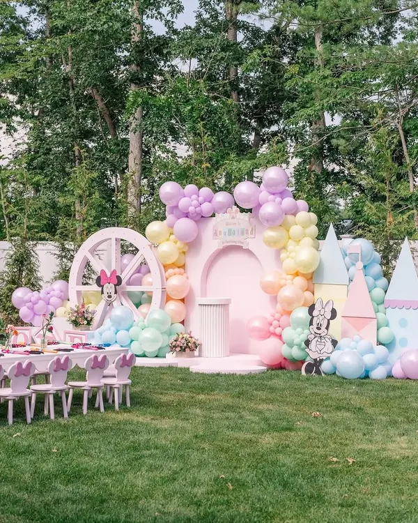 A complete outdoor setup for a pastel Disney-themed party. This "Anayaland" features a main stage, themed kids' tables, a castle prop, and character cutouts, creating an immersive and magical experience for the children.