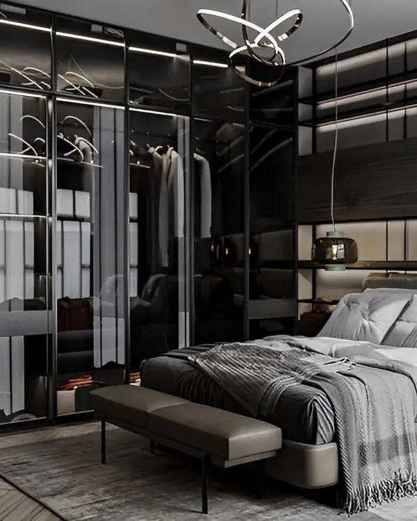 A sophisticated master bedroom featuring a large wardrobe with smoked glass doors and integrated lighting. This design turns clothing storage into a stunning display feature.
