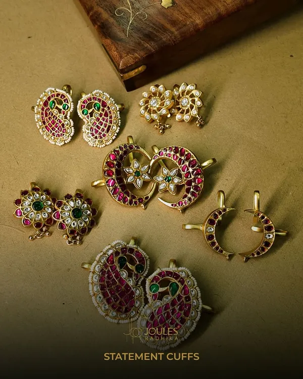 Sculpted for style, designed for impact. This is a flat lay of our statement cuffs, showcasing a variety of designs from paisley motifs to crescent moons, all handcrafted with polki, rubies, and emeralds.