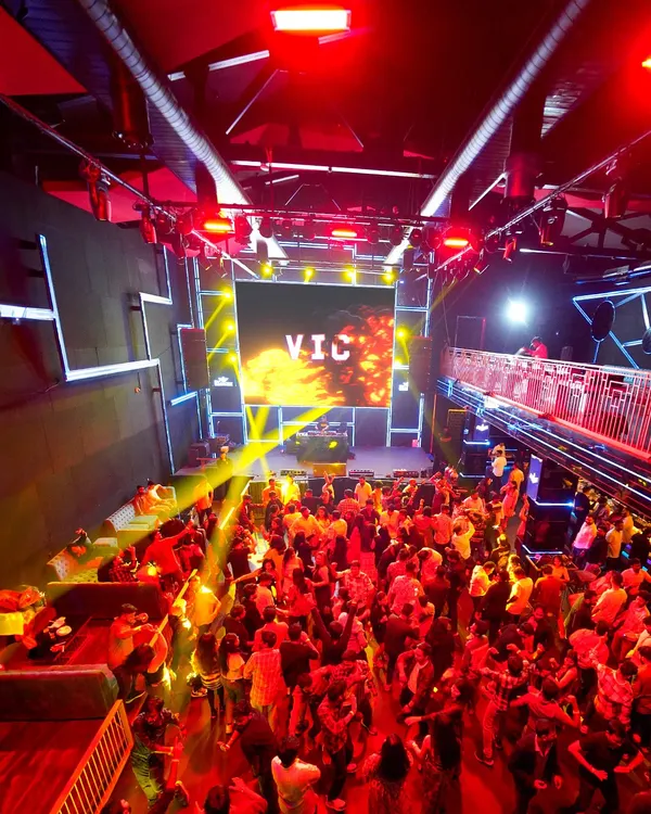 A view from above at a packed corporate party at Ignite Superclub. My custom "VIC" branding on the main LED screen and the vibrant lighting design show how I transform a venue into a high-energy audio-visual spectacle.