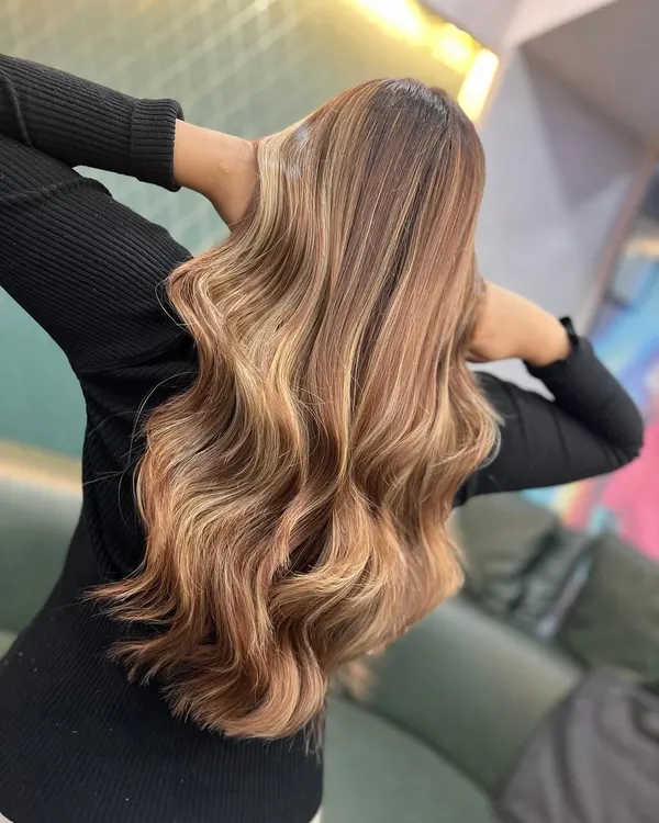 This beautiful brownish-blonde look with soft, warm tones was created entirely by students during a masterclass. This shows the back view, highlighting the seamless blend of colours.