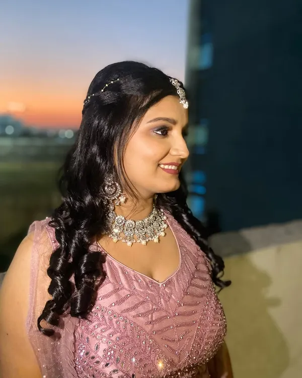 A beautiful Sangeet bride against a sunset backdrop. I created a glamorous look with smokey eyes and bold lips, perfect for a night of music and dancing.
