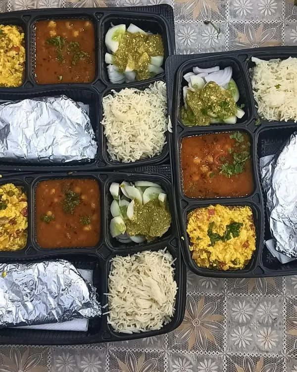 A set of my standard vegetarian thalis ready for delivery. This meal included Paneer Bhurji, Chana Masala, fresh salad with green chutney, fluffy rice, and foil-wrapped rotis to keep them soft.