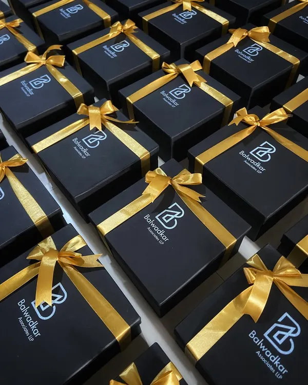 A fleet of our signature black and gold gift boxes, custom branded for Balwadkar Associates. This is how we execute large orders with a consistent, premium, and elegant finish.