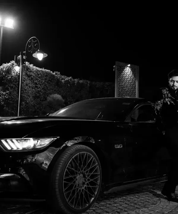 Modern groom, classic style. This black and white shot with a Ford Mustang creates a cool, cinematic feel, perfect for capturing the groom's personality.